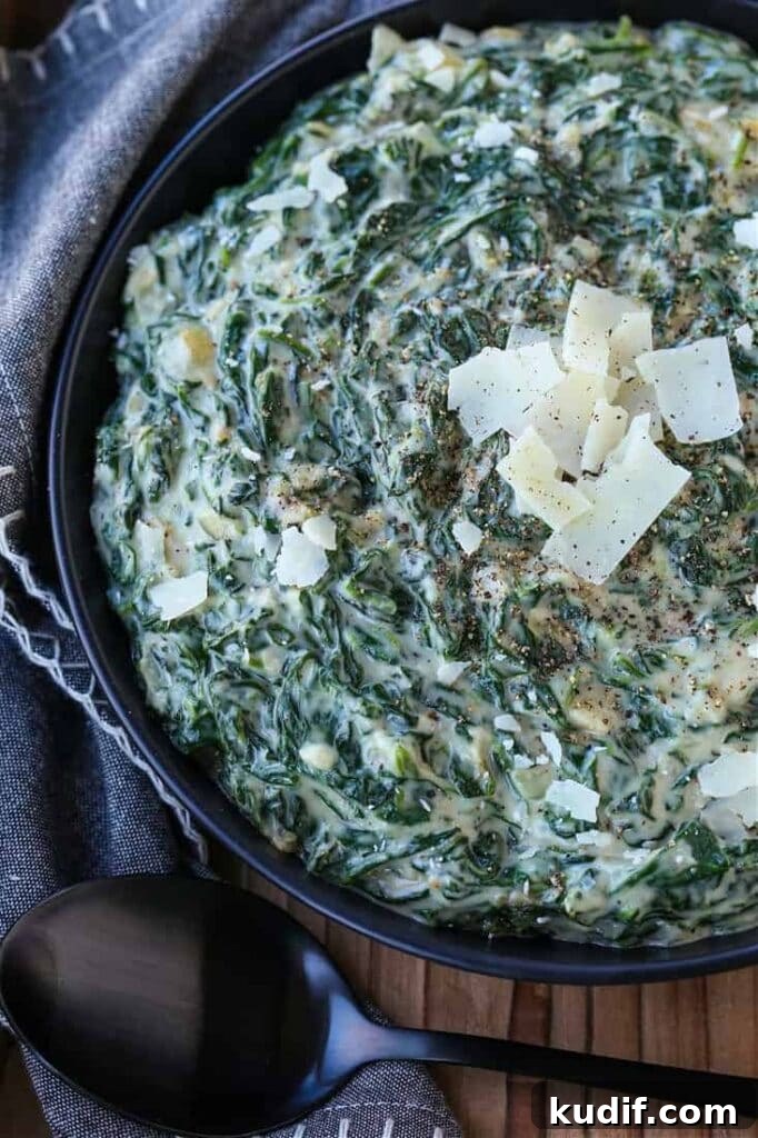 Creamed Spinach in a black bowl with parmesan cheese