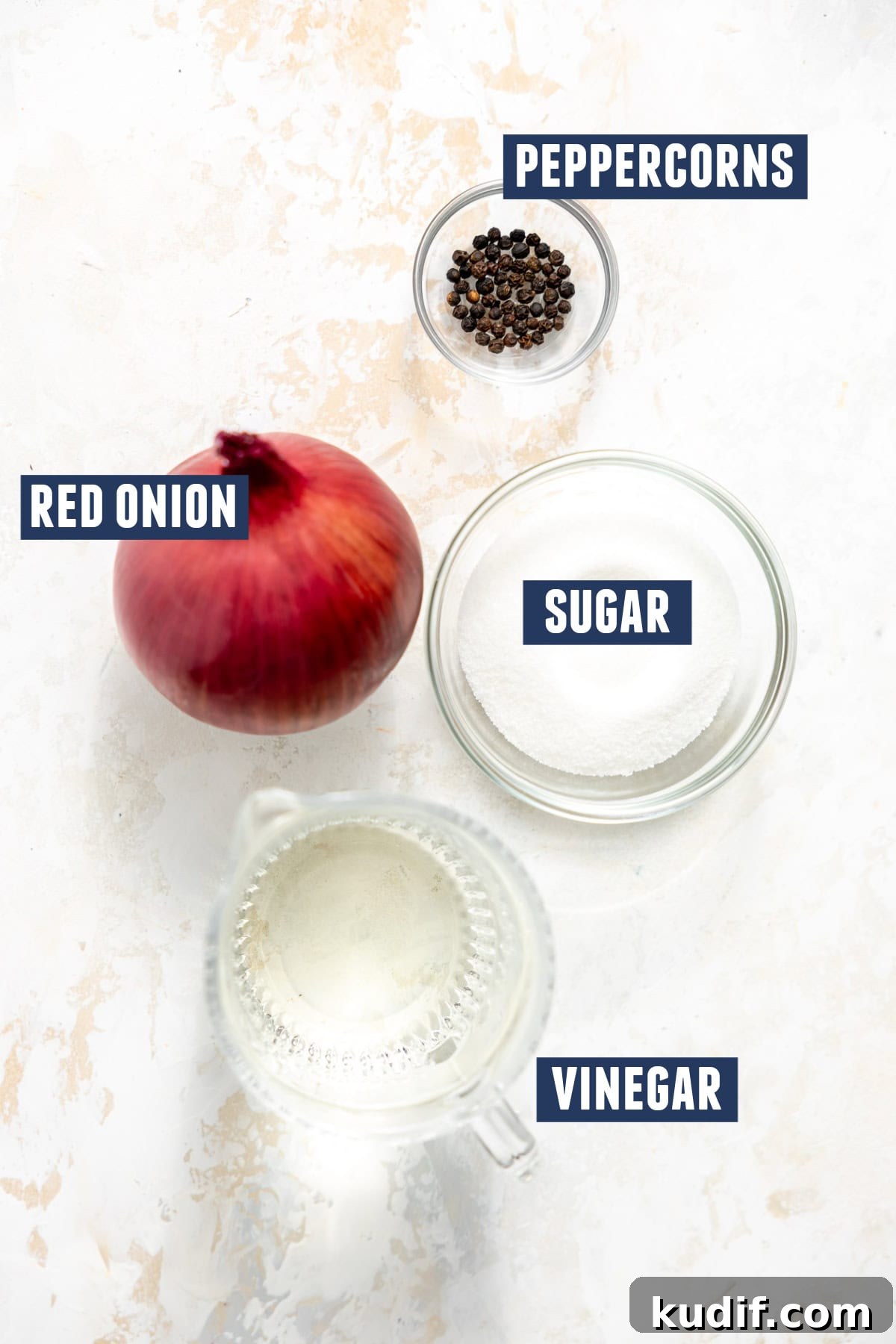 Quick Pickled Red Onions Recipe for Salads & Sandwiches 5 Ingredients needed to make pickled red onion including the red onion, peppercorns, sugar, and vinegar.