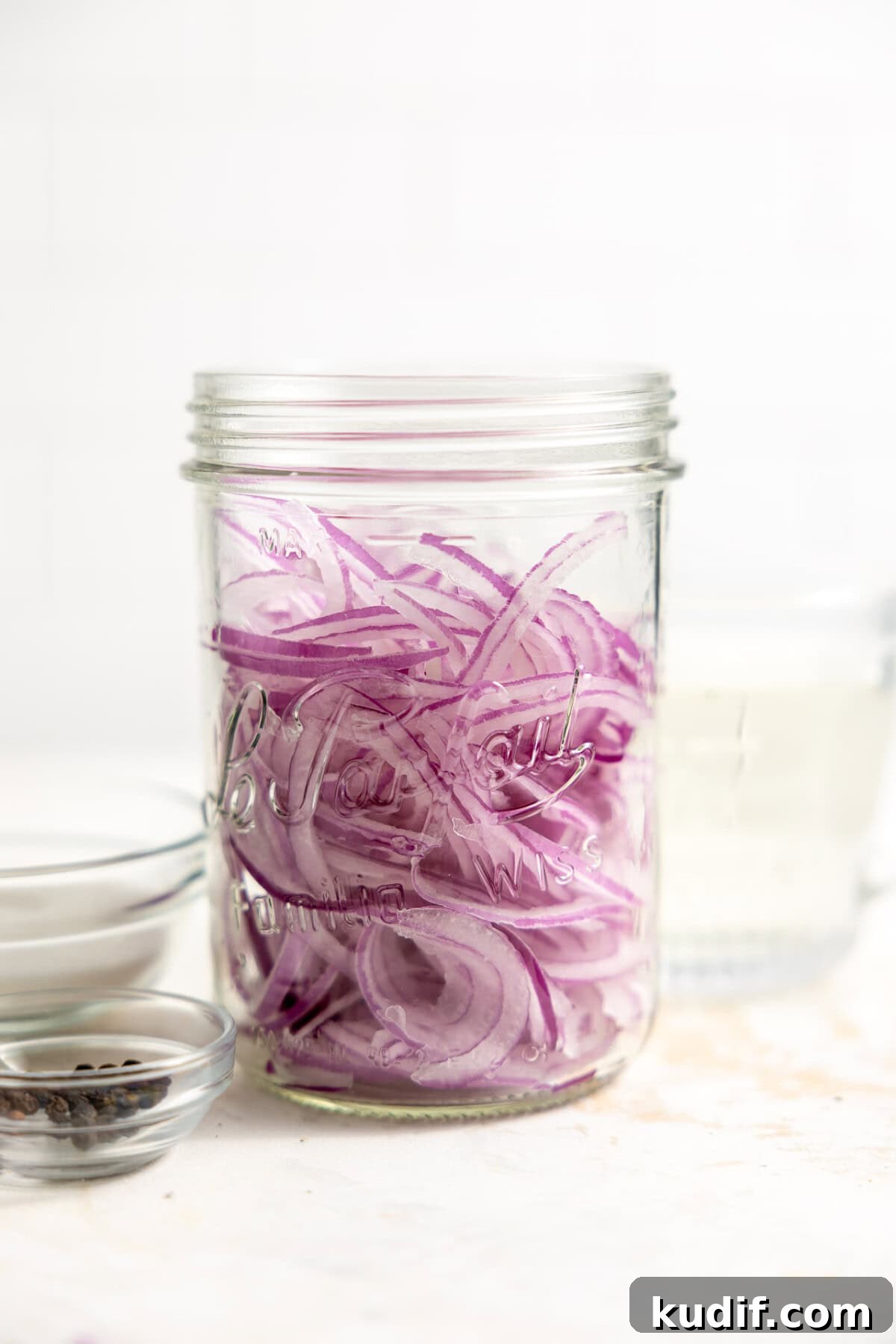 Quick Pickled Red Onions Recipe for Salads & Sandwiches 7 Thinly sliced red onions in a jar.