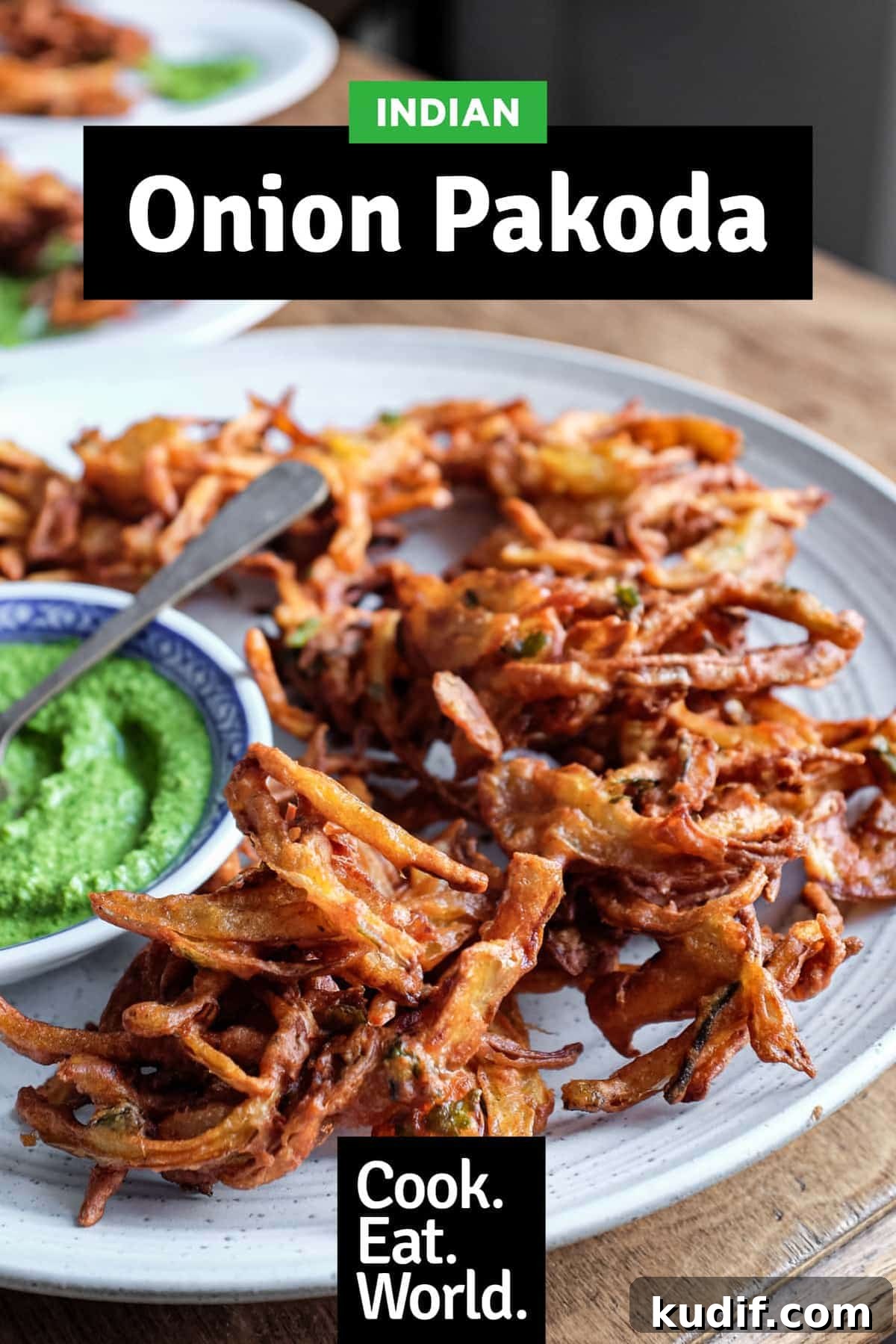 Crispy Onion Pakoda Recipe: Indian Onion Fritters Guide 11 Fried onion pakodas on a platter with a small bowl of coriander chutney and a small spoon.