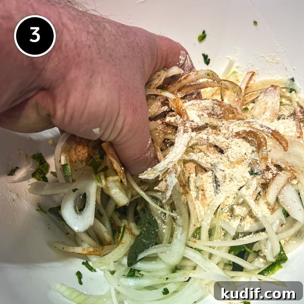 Crispy Onion Pakoda Recipe: Indian Onion Fritters Guide 4 Combining the sliced onions by hand with gram flour and spices