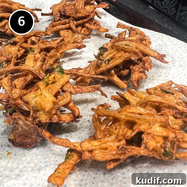 Crispy Onion Pakoda Recipe: Indian Onion Fritters Guide 7 Onion Pakoda draining on paper towels