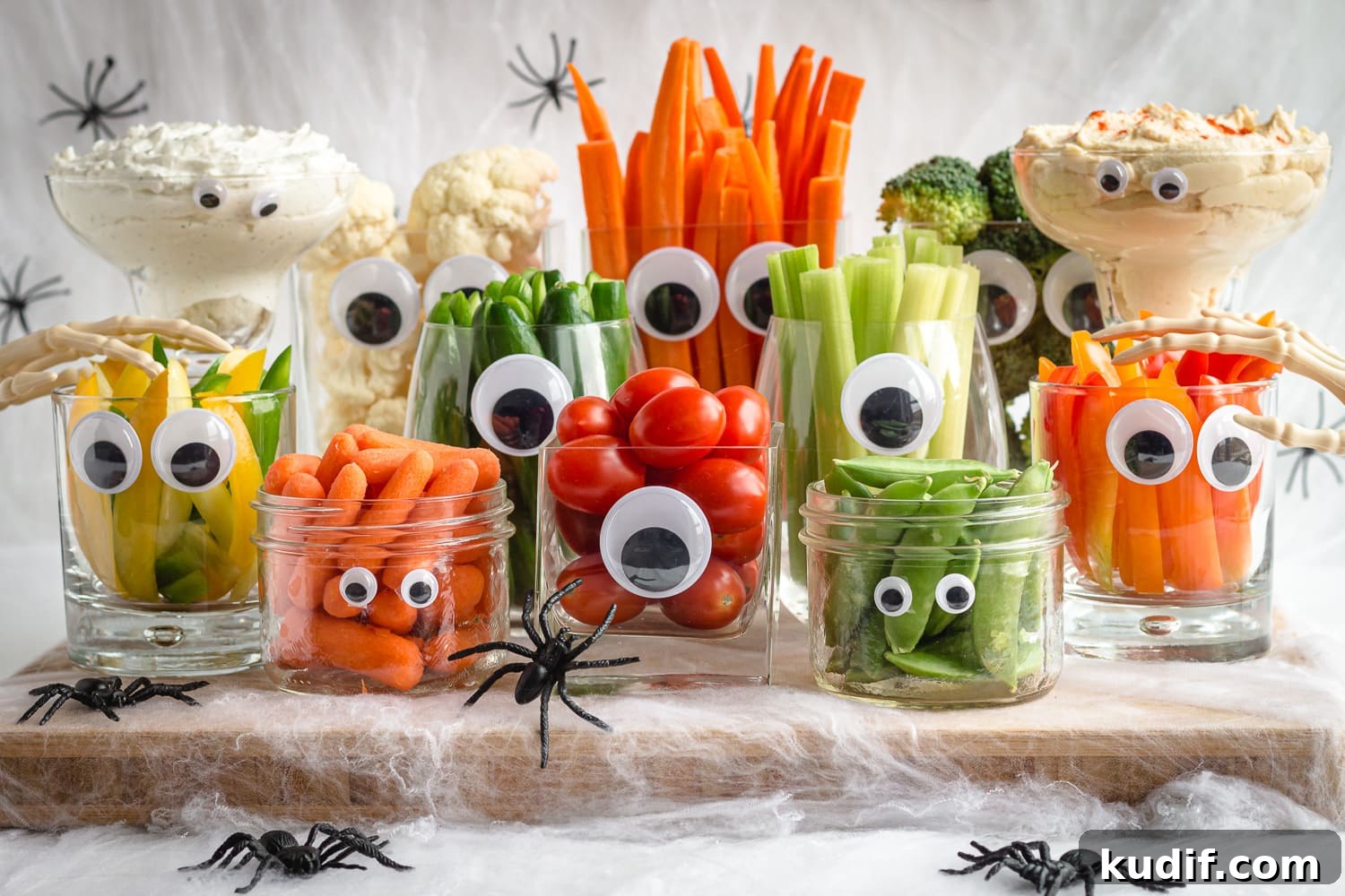 Monster-Themed Halloween Veggie Tray Ideas for Parties 2 A Halloween veggie tray featuring "monsters" made from glassware with googly eyes which are then filled with a variety of different veggies and dip.