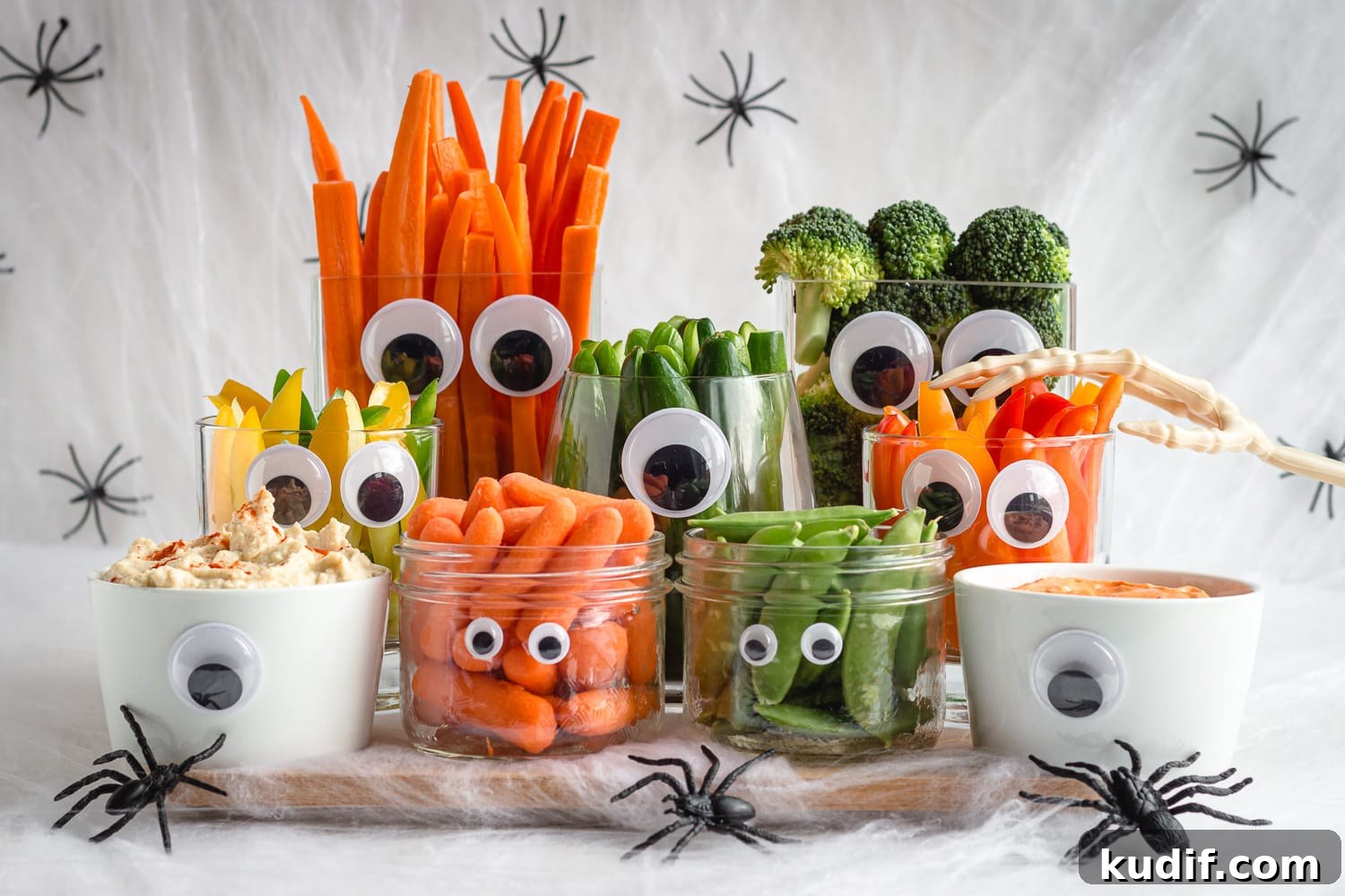 Monster-Themed Halloween Veggie Tray Ideas for Parties 3 Halloween themed vegetables and dip surrounded by fake cobwebs and spiders.