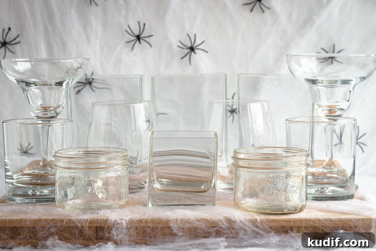 Monster-Themed Halloween Veggie Tray Ideas for Parties 4 Variety of glassware set on a wooden board surrounded by fake cobwebs and spiders.
