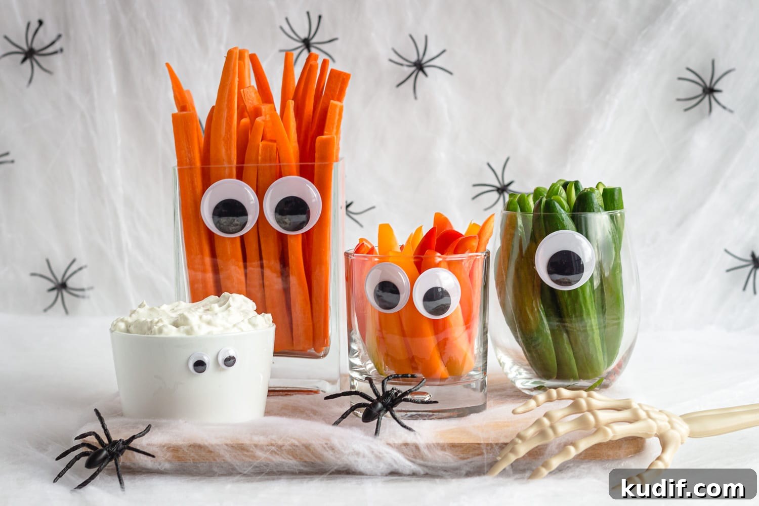 Monster-Themed Halloween Veggie Tray Ideas for Parties 7 Simple Halloween veggie tray featuring carrots, peppers, cucumber and dip in glassware with googly eyes.