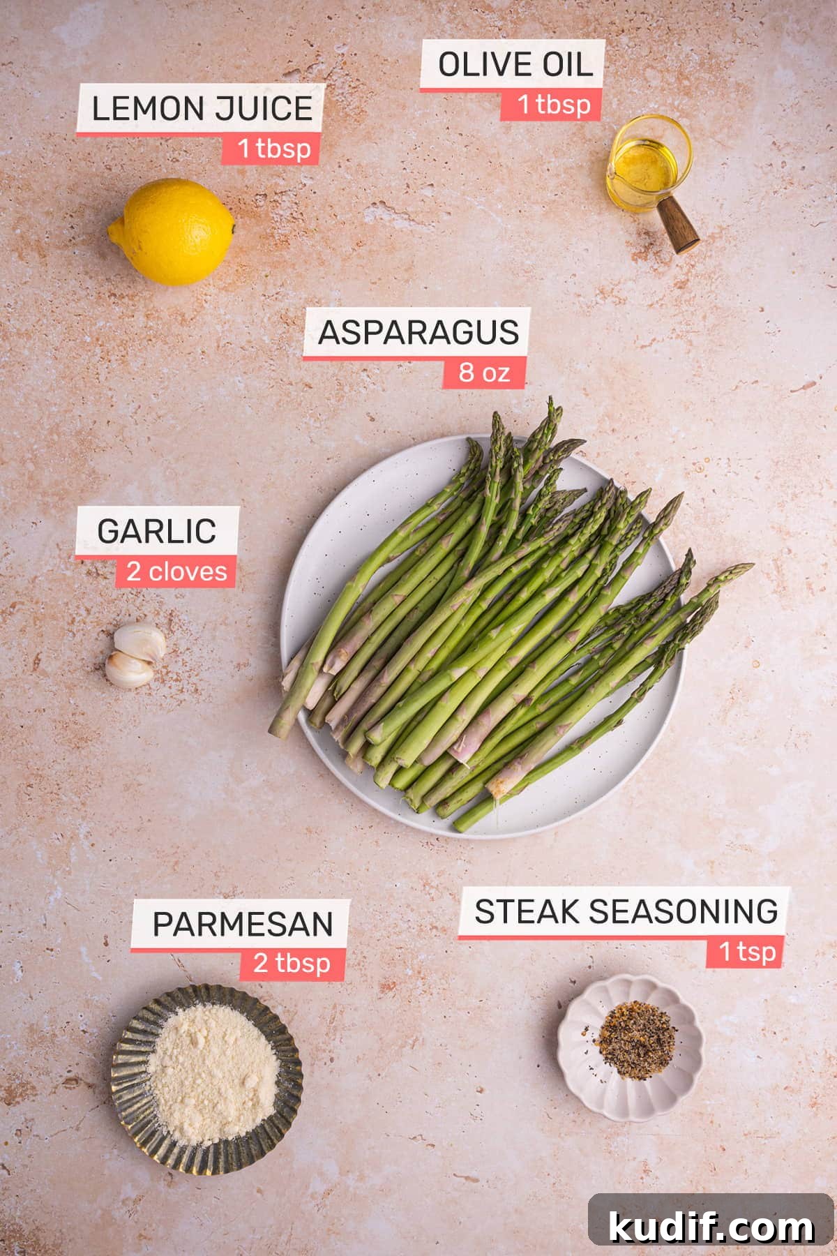 20-Minute Garlic Lemon Asparagus Recipe for Quick Weeknight Sides 3 overhead view of all ingredients needed for garlic lemon asparagus on a pink granite background - asparagus, olive oil, lemon, garlic, parmesan, steak seasoning