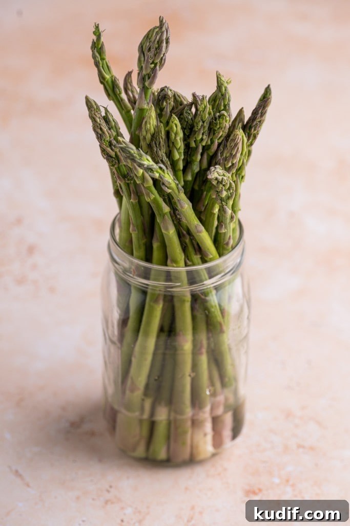 20-Minute Garlic Lemon Asparagus Recipe for Quick Weeknight Sides 4 asparagus stored in a mason jar with ends submerged in water