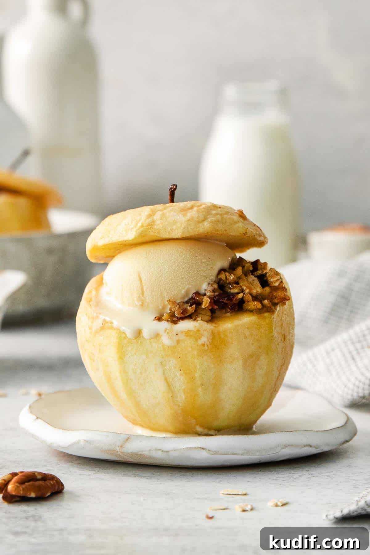 Baked Apples Recipe: Gluten-Free Cinnamon-Stuffed Dessert 3 A baked apple with filling and a scoop of ice cream on a plate