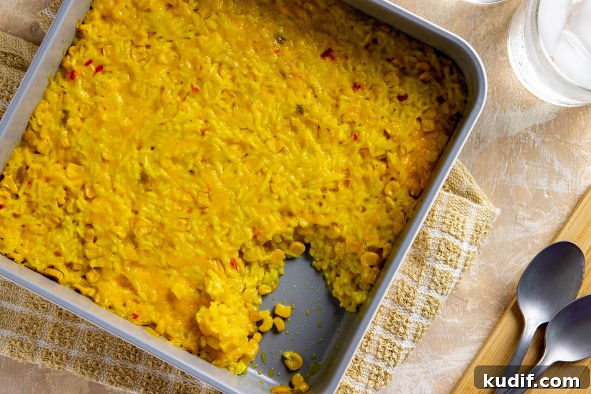 Cheesy Corn and Rice Casserole with Bacon and Green Chiles 7 Baked corn and rice casserole in square casserole dish with a serving in the corner that's been scooped out.