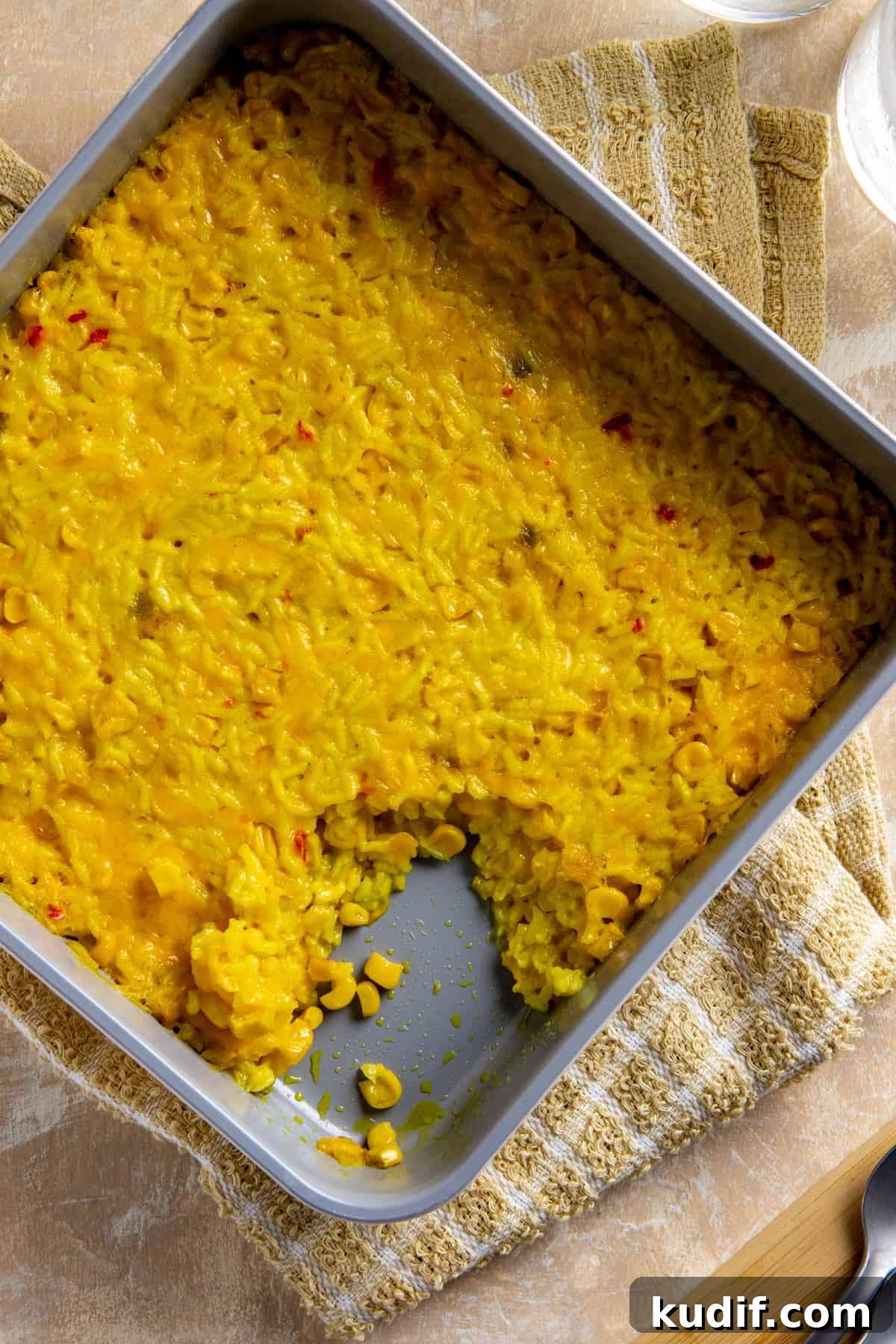 Cheesy Corn and Rice Casserole with Bacon and Green Chiles 8 Baked corn and rice casserole in square casserole dish with a serving in the corner that's been scooped out.