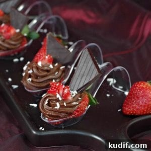 4 Chocolate Avocado strawberry desserts on spoons on a black appetizer tray