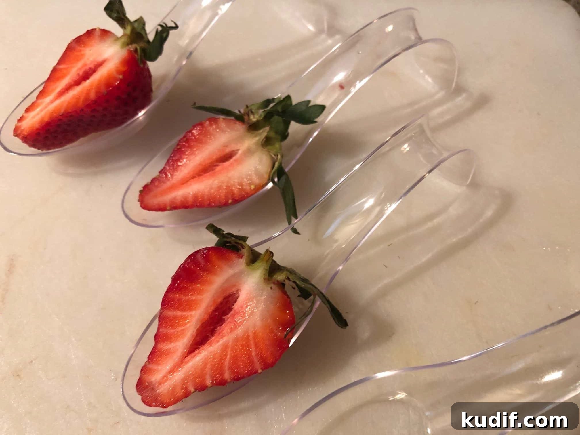 strawberries cut in half in bottom of spoon
