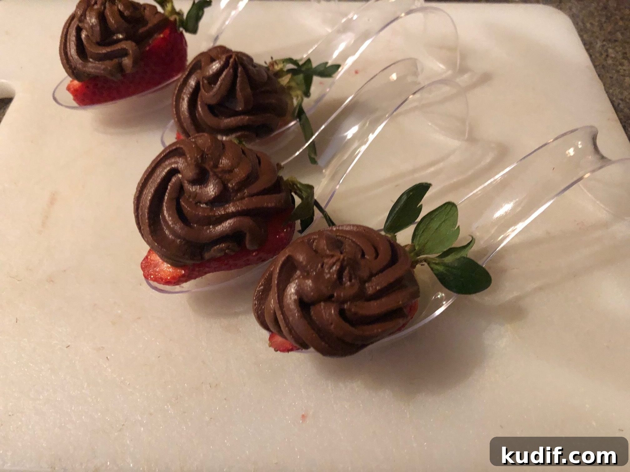 Chocolate avocado mousse piped on half a strawberry