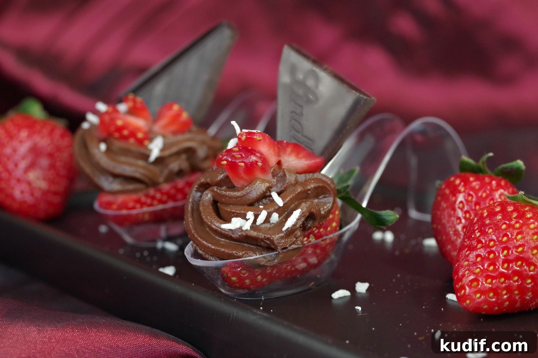 2 Chocolate Avocado & Strawberry mini desserts on a spoon on a black appetizer tray