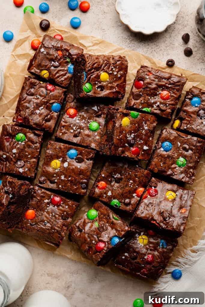 A bird's eye view of the sliced m&m brownies on a piece of parchment paper.