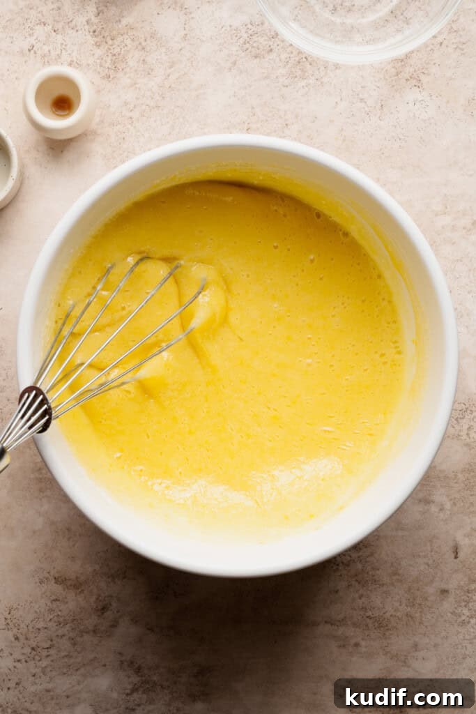 A bowl of the sugar and egg mixture being whisked.