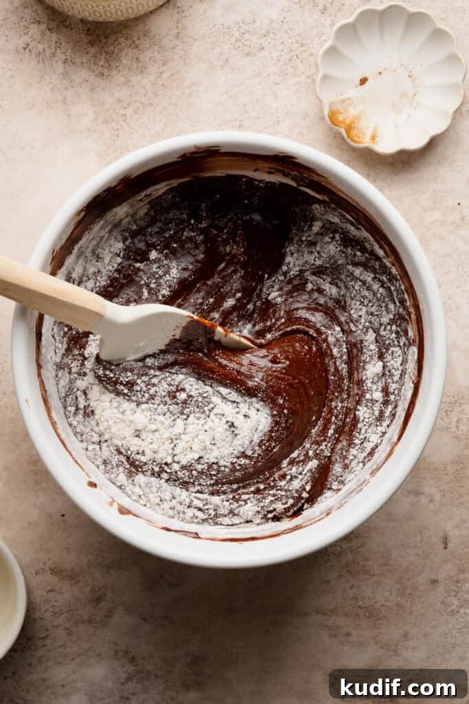 Flour being folded into the brownie batter.
