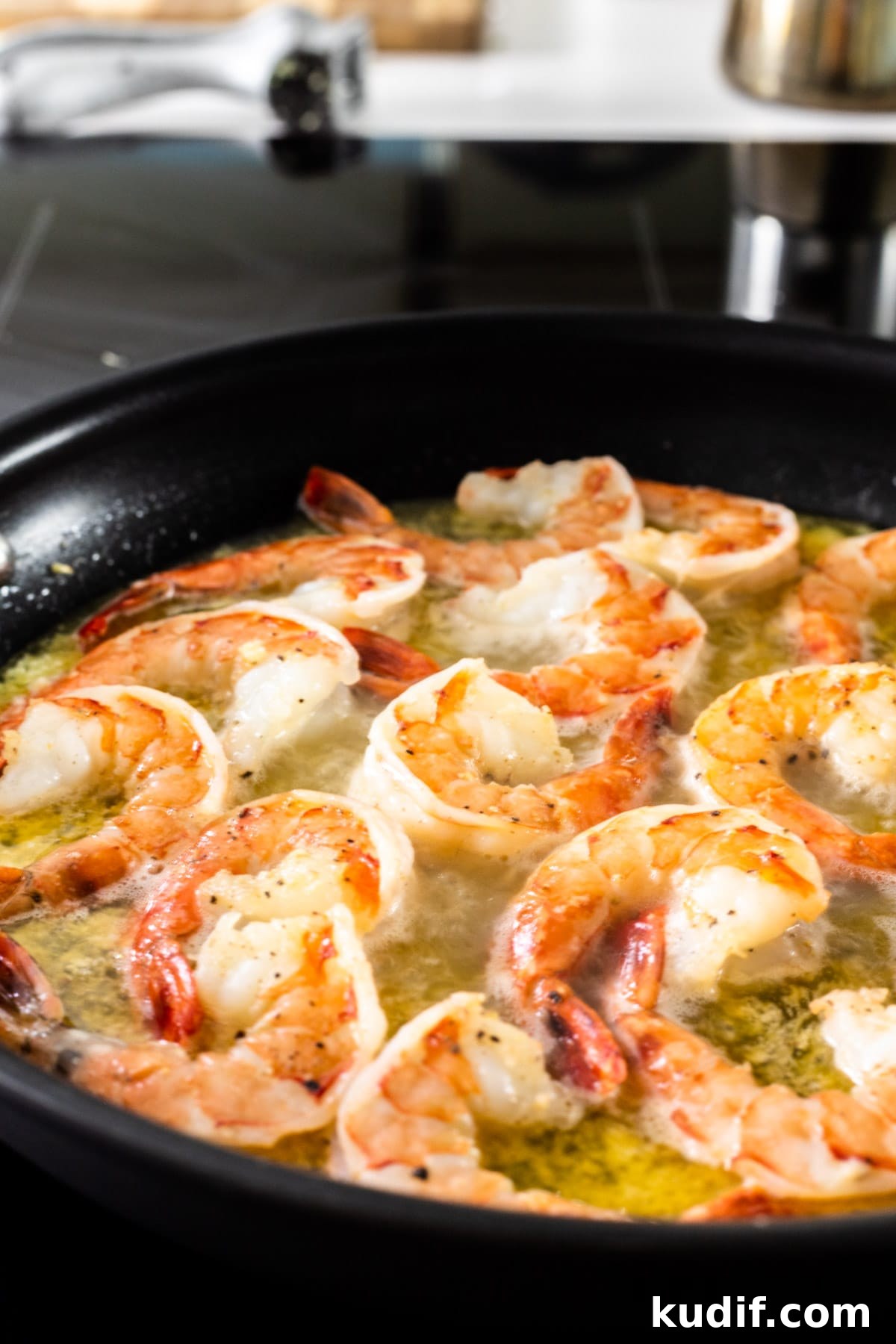 Cilantro-Lime Shrimp Pasta with Garlic and Parmesan 4 Seasoned shrimp cooking in a skillet of butter and oil.