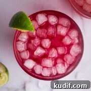 prune juice cocktail served in a cup and garnished with a slice of lime