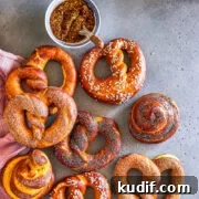 pretzels with different toppings alongside a mustard dip