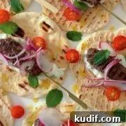 venison koftas on a tortilla wrap served with tomato slices