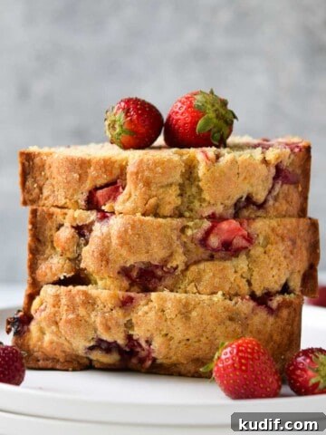Strawberry buttermilk bread, sliced and stacked on a white plate.