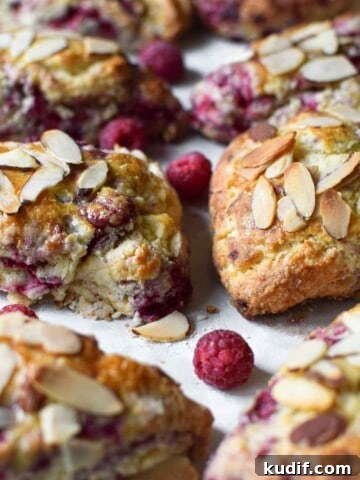 Close-up of raspberry almond scones on parchment paper.