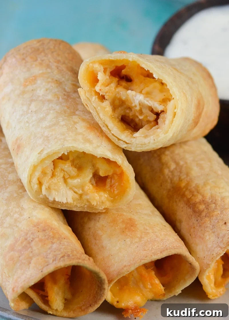 Spicy Buffalo Chicken Taquitos Recipe for Game Day Snacks 7 a stack of crispy buffalo chicken taquitos on a plate beside a ramekin of ranch dip