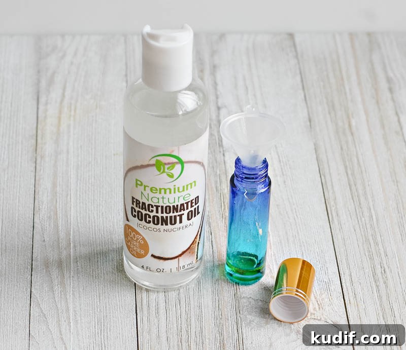 Calming Kids Roller & Spray Blend: DIY Calming Oils for Children 6 fractionated coconut oil next to an open roller ball with a funnel inside