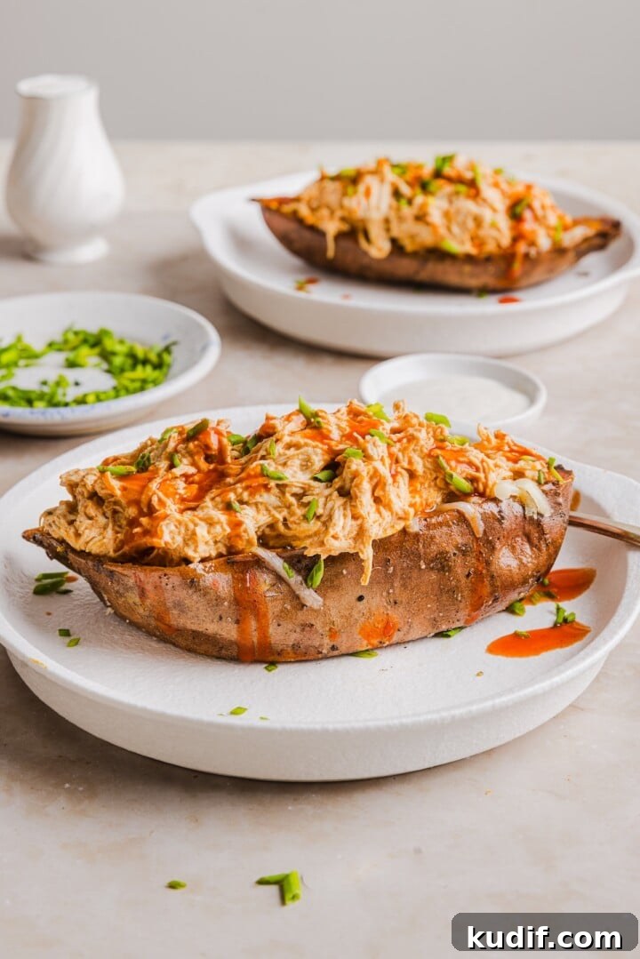 Buffalo Chicken Stuffed Sweet Potatoes Recipe for Spicy Weeknight Meals 2 Buffalo chicken sweet potato boats in the slow cooker, topped with shredded cheese and chives.
