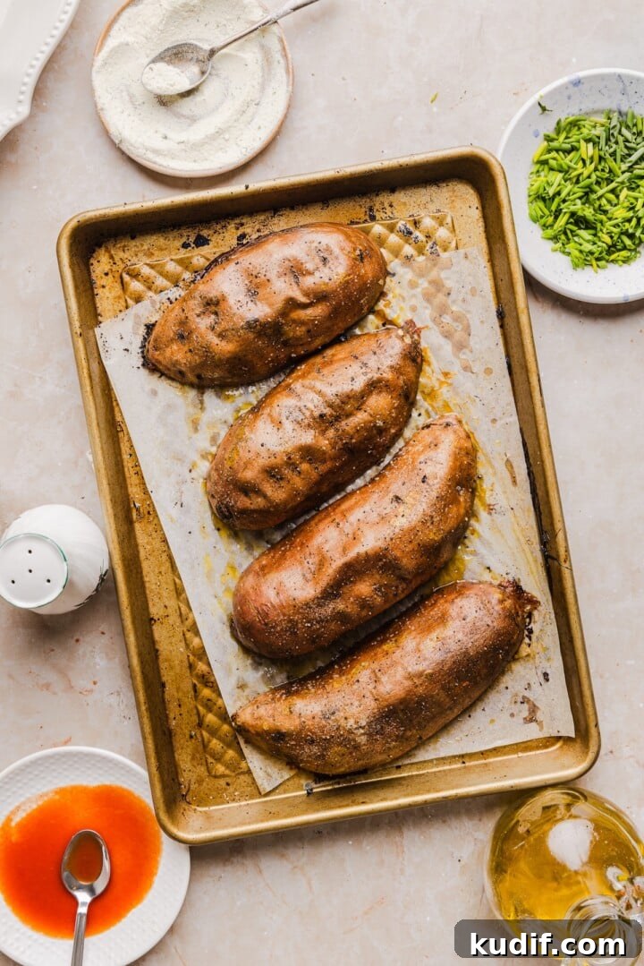Buffalo Chicken Stuffed Sweet Potatoes Recipe for Spicy Weeknight Meals 5 Roasted sweet potato halves on a sheet pan.
