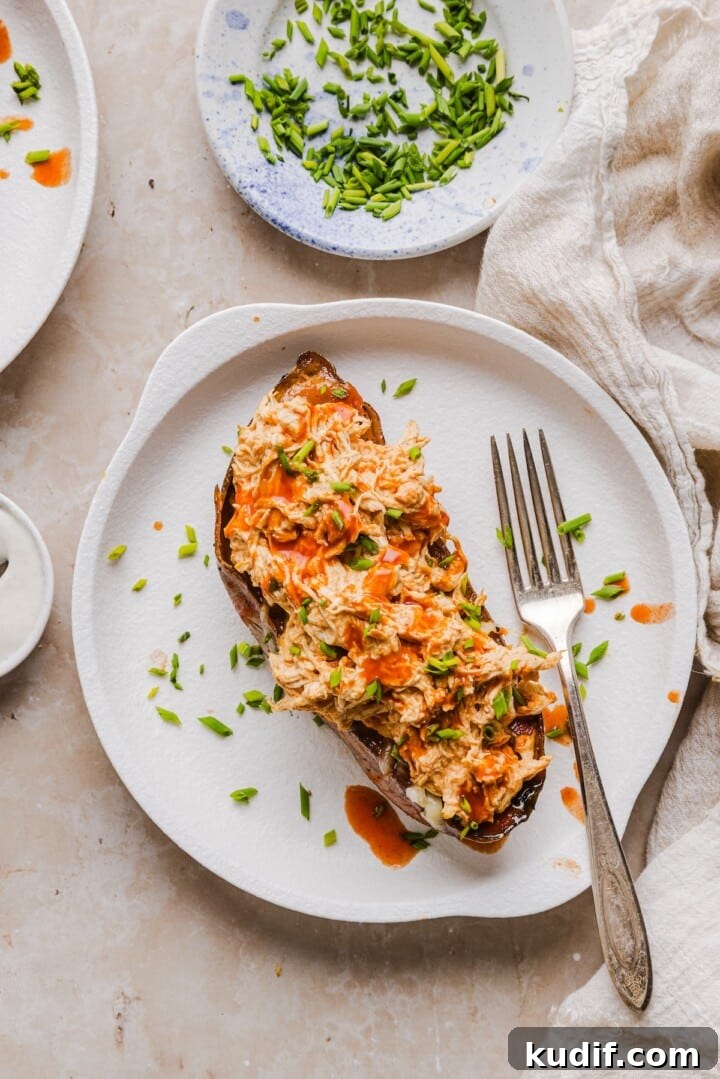 Buffalo Chicken Stuffed Sweet Potatoes Recipe for Spicy Weeknight Meals 7 Sweet potato boats with shredded cheese, shredded buffalo chicken, and diced chives.