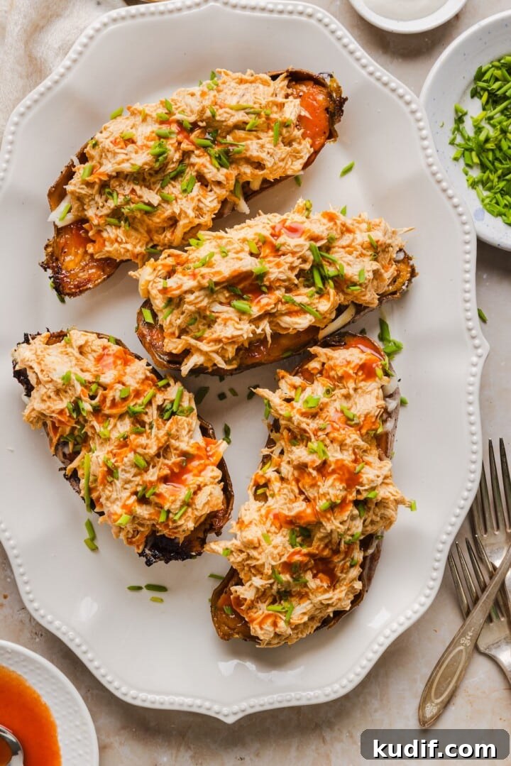 Buffalo Chicken Stuffed Sweet Potatoes Recipe for Spicy Weeknight Meals 8 Buffalo chicken stuffed sweet potatoes on a white serving tray.