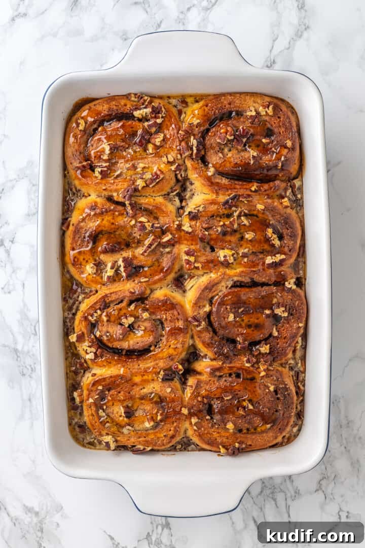 Pour over maple syrup. Overhead view of baked cinnamon roll French toast in pan after adding maple syrup
