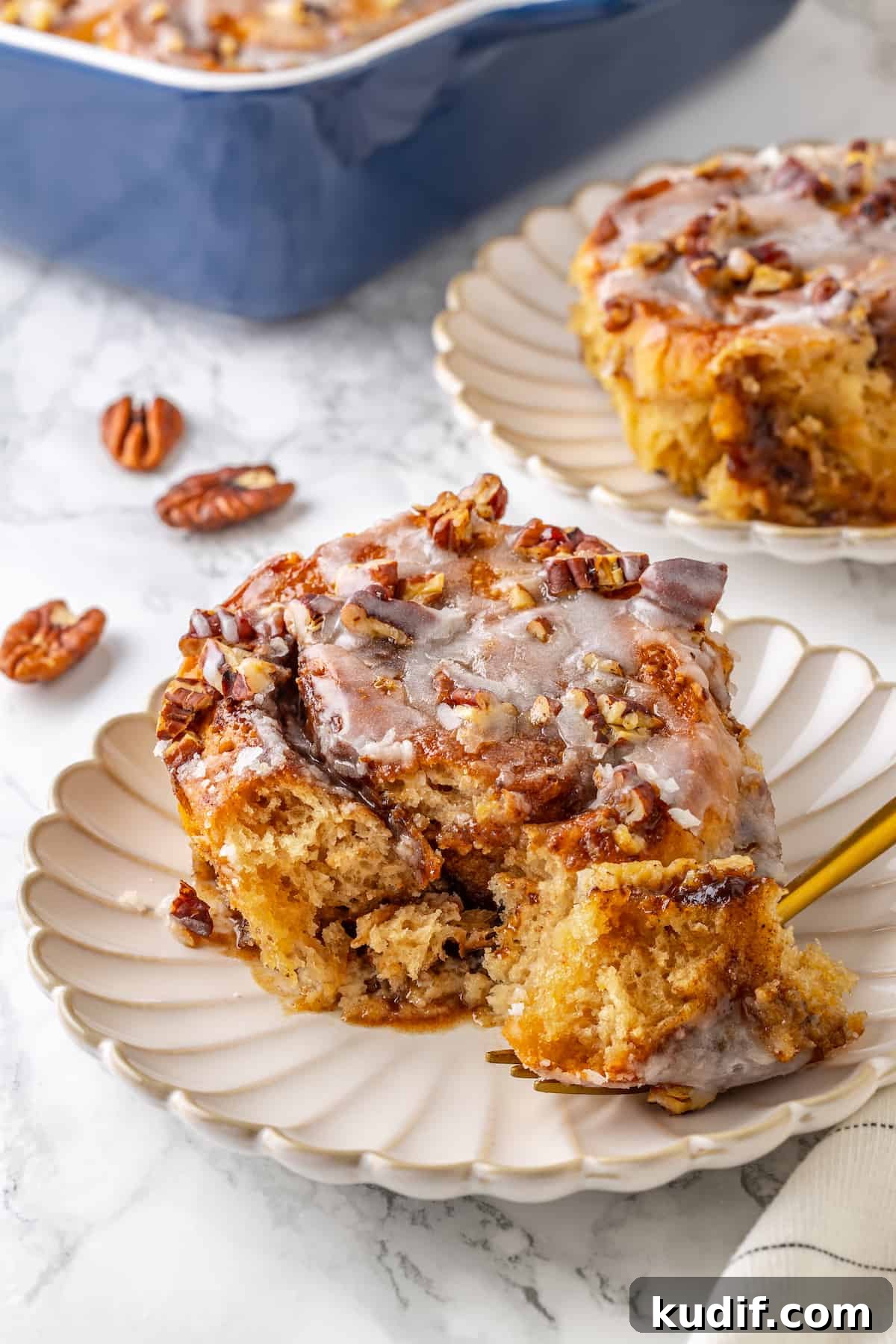 This vegan cinnamon roll French toast recipe has soft homemade cinnamon rolls baked in custard. The best cozy breakfast or holiday brunch! Portion of cinnamon roll French toast on plate with fork