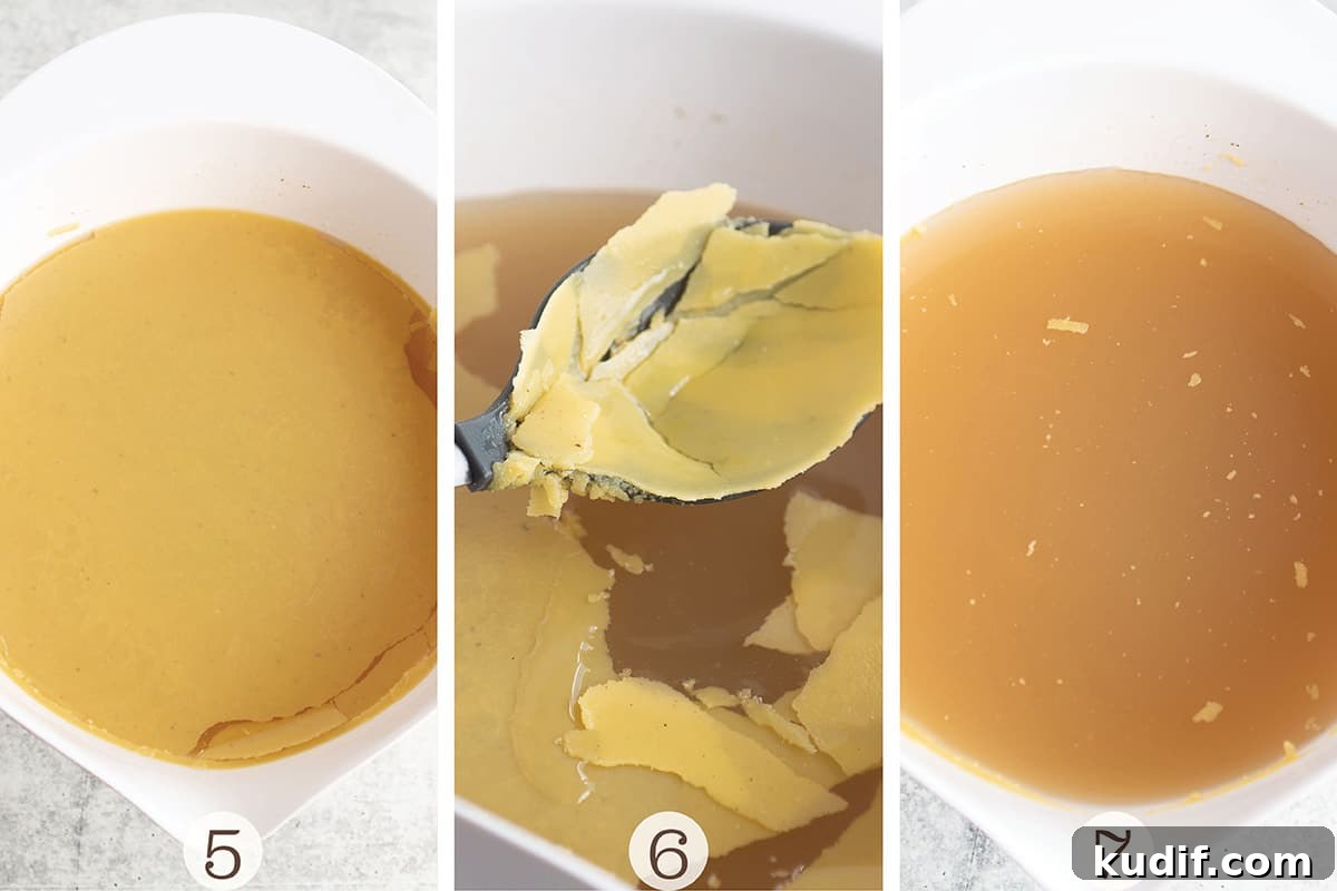 Nourishing Turkey Bone Broth Recipe for Deep Flavor and Gelatin 4 A white bowl with a turkey broth and fat sitting on top with a slotted spoon scooping it out.