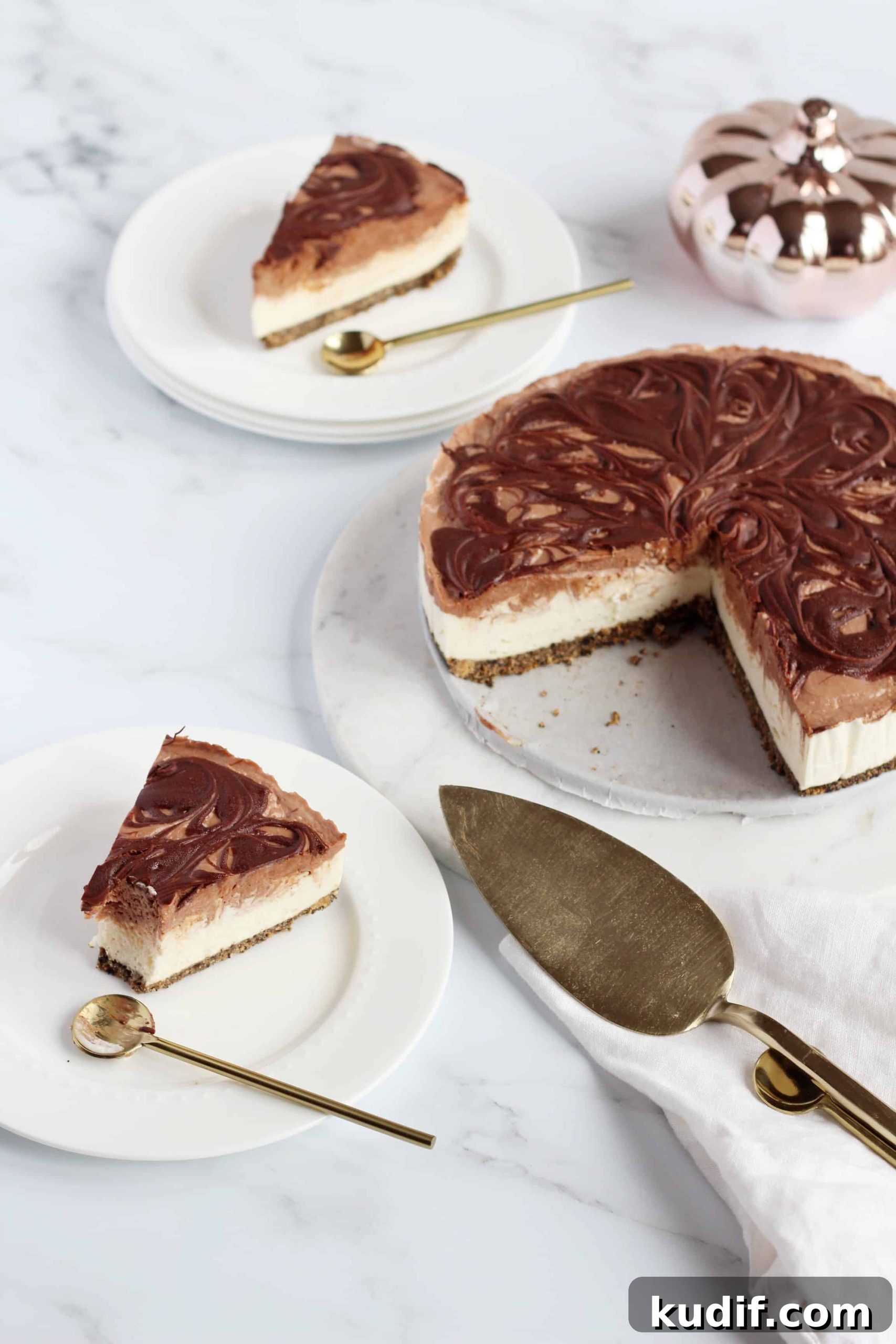 Nutella swirl Cheesecake cut out two slices on white plates with golden spoons