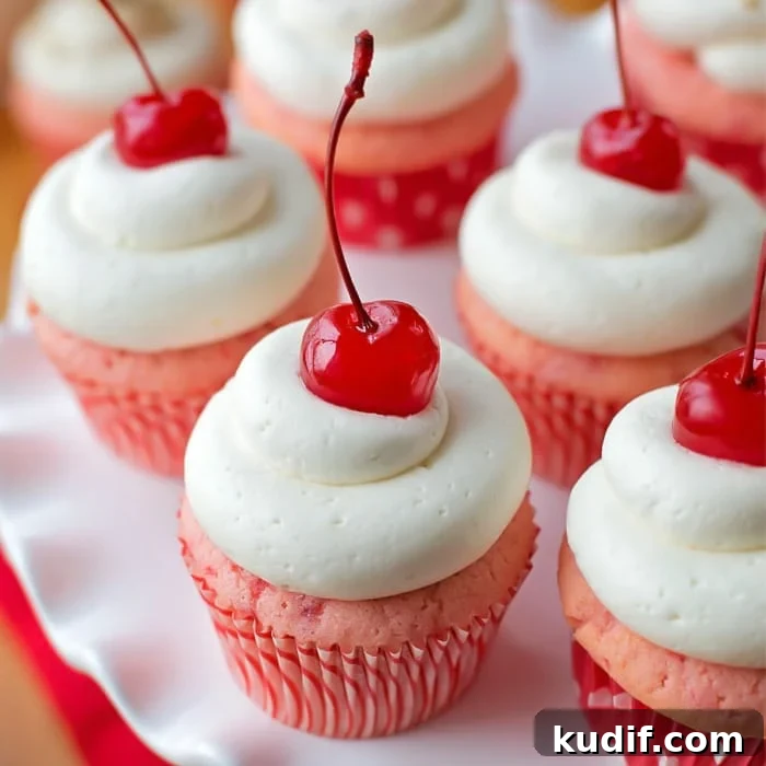 Cherry Almond Cupcakes with Cherry Glaze and Almond Crunch 2 Cherry almond cupcakes on white cake stand.