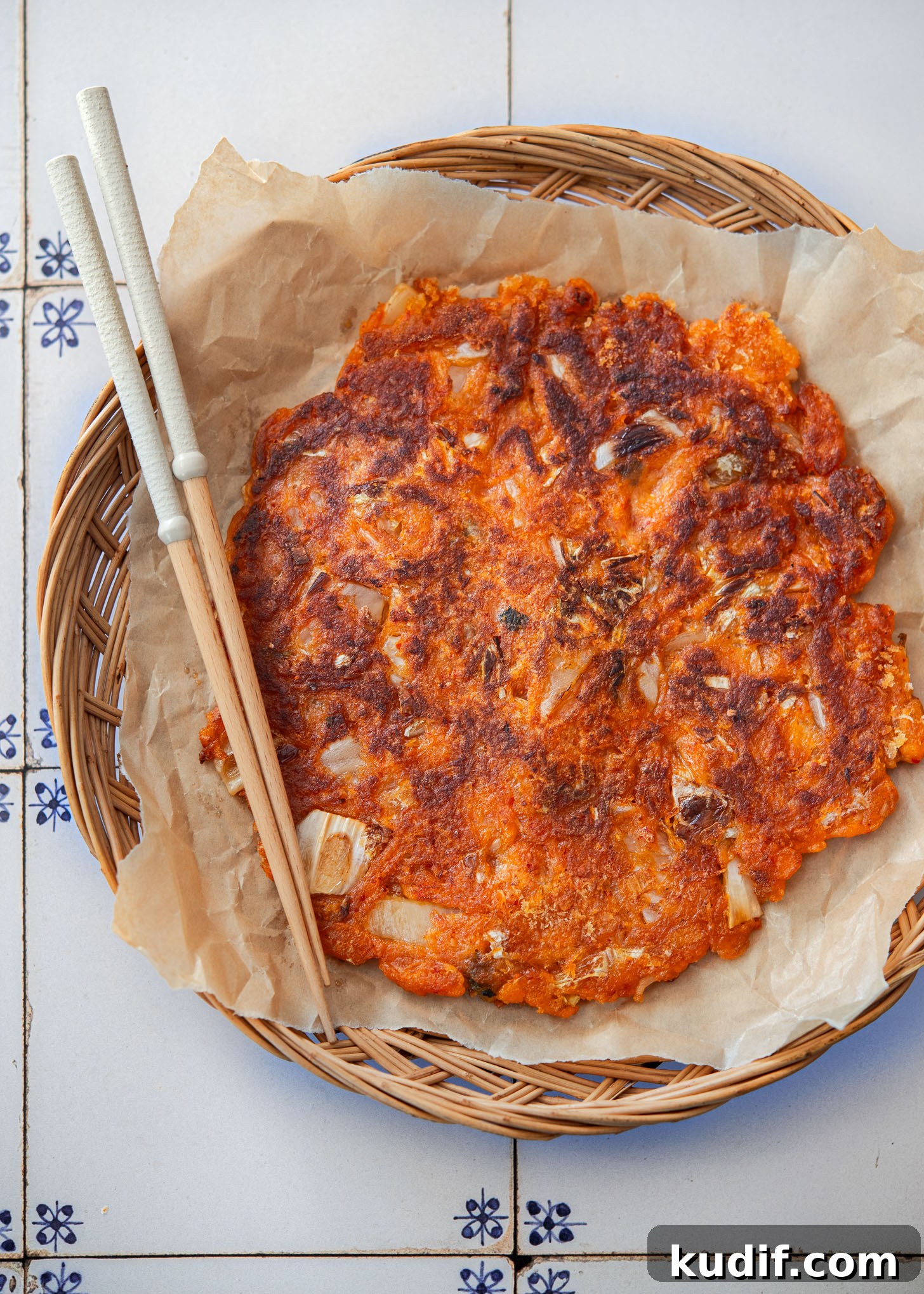Crispy Kimchi Pancakes (Kimchi Jeon) Recipe for Perfect Pan-Fried Kimchi Cakes 2 Crispy kimchi pancake (kimchi jeon) with a piece removed to reveal the tender interior