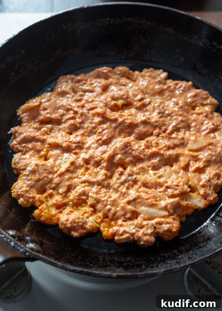Crispy Kimchi Pancakes (Kimchi Jeon) Recipe for Perfect Pan-Fried Kimchi Cakes 10 Kimchi pancake batter spread thin in a hot pan for frying.
