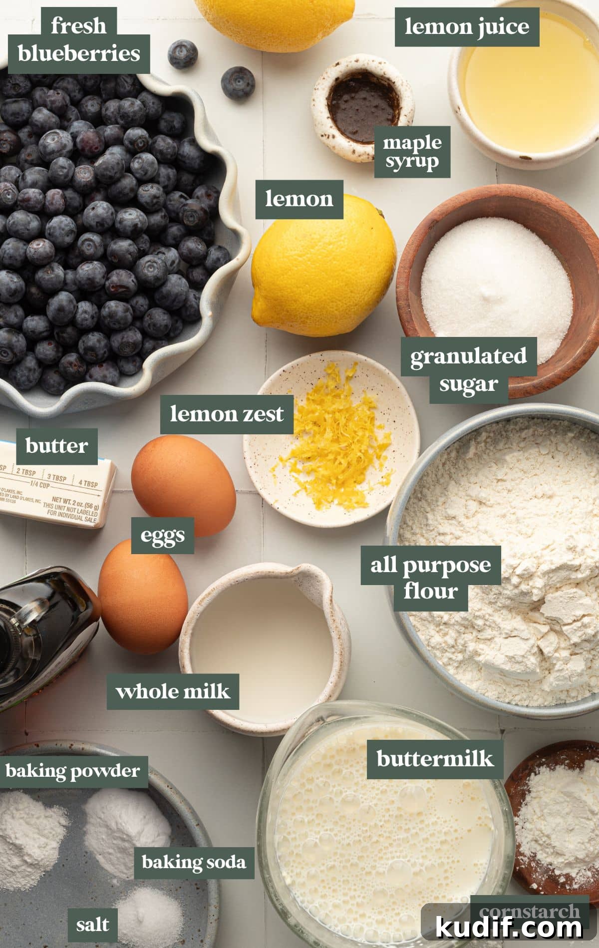 Lemon Pancakes with Blueberry Maple Syrup Recipe 5 A flat-lay image of various baking ingredients labeled with text, arranged on a light-colored surface.