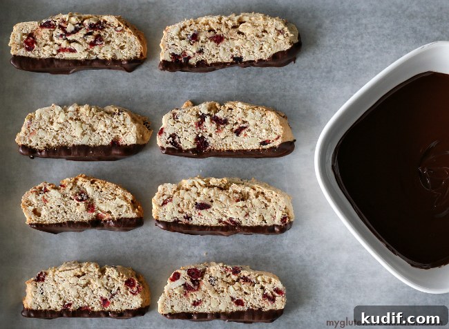 Gluten-free Chocolate Dipped Almond Biscotti sliced next to a bowl of melted chocolate