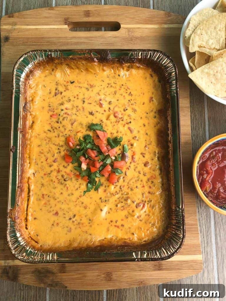 Smoked Queso Dip Recipe: Creamy, Smoky Cheese Dip for Parties 2 smoked queso dip topped with cilantro and diced tomato next to bowl of salsa with chips