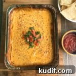 Smoked queso dip topped with cilantro and diced tomato overhead shot