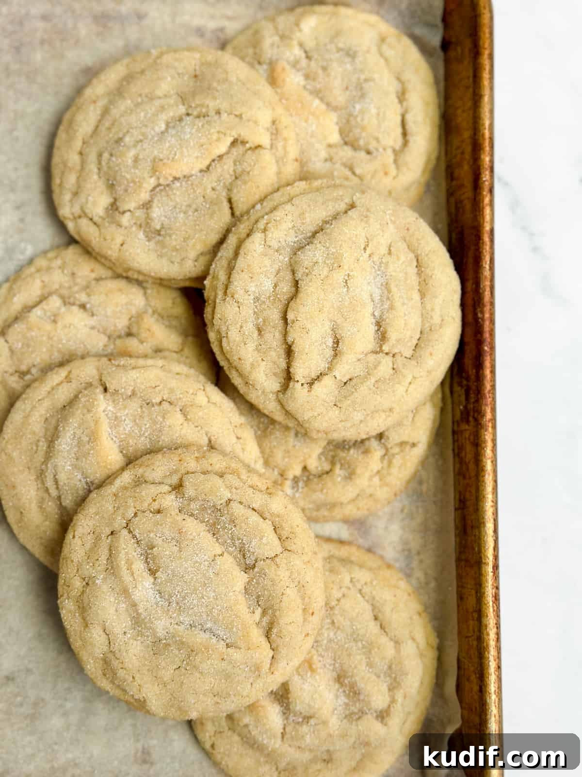 all the brown butter sugar cookies layered on top of each other on a baking sheet.