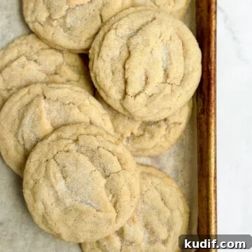 all the brown butter sugar cookies layered on top of each other on a baking sheet.