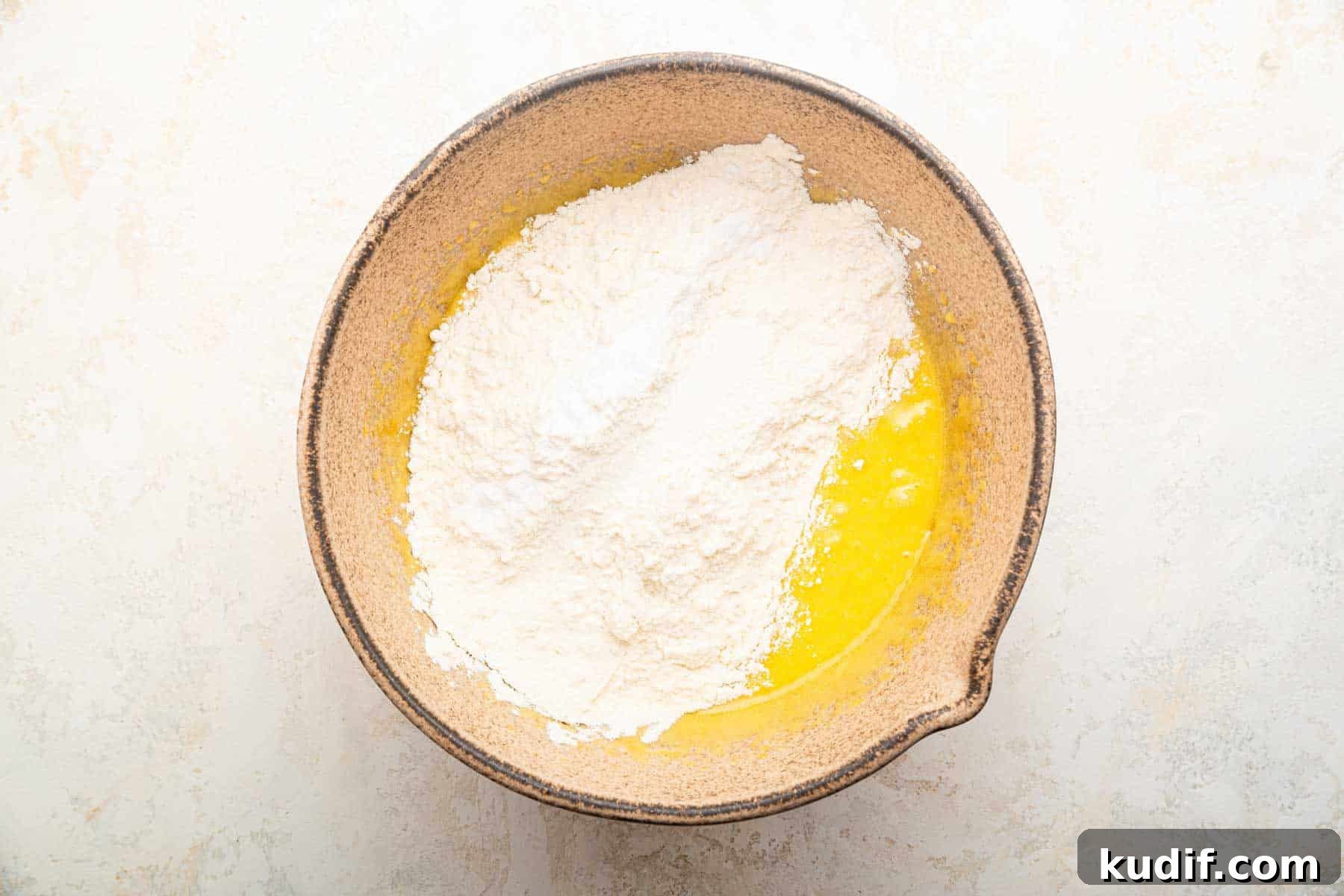 Crème Brûlée Cookie Recipe: Crispy Edges, Gooey Center 6 Flour on top of melted butter in a brown bowl.