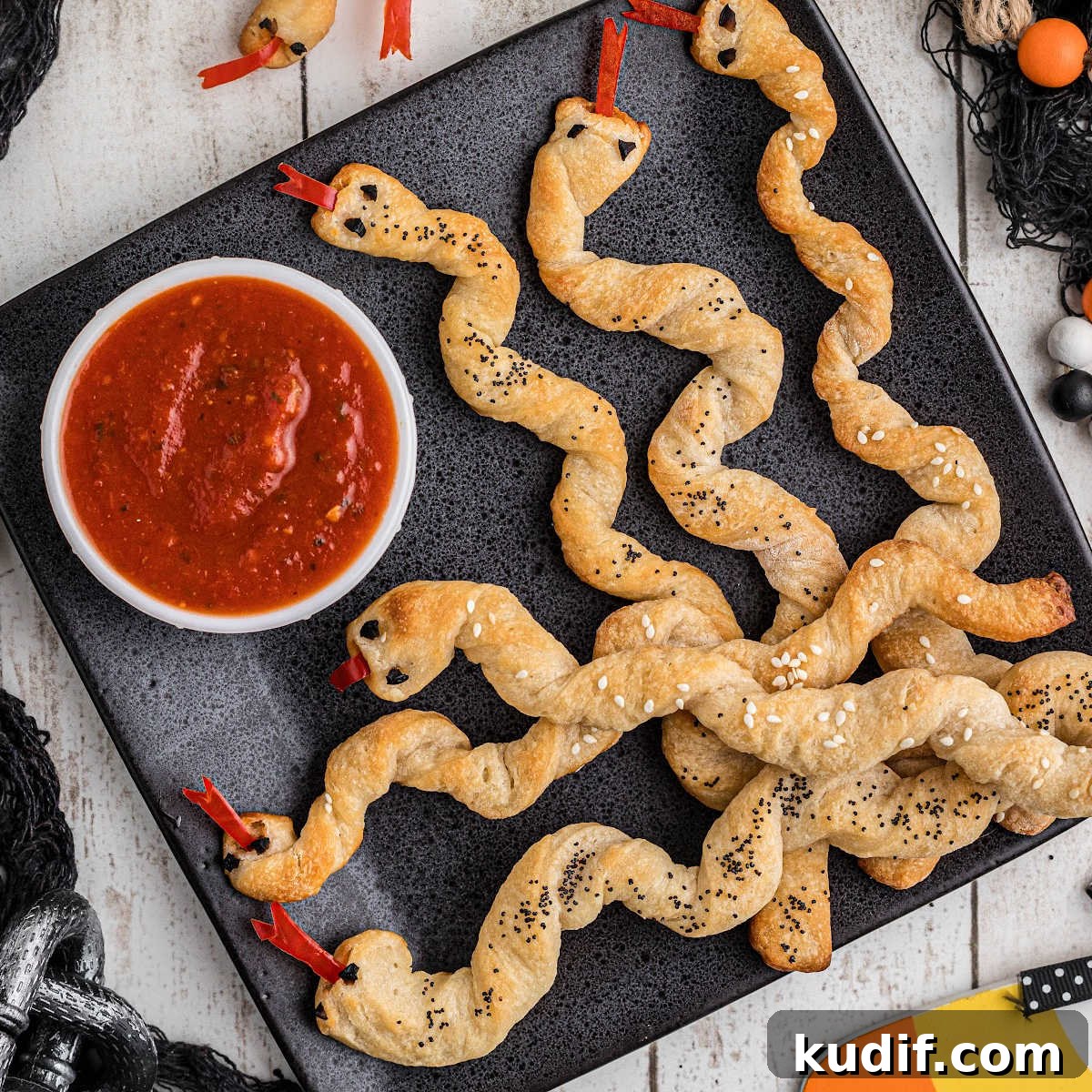 15 Spooky Halloween BBQ Recipes for Party-Worthy Grilling 3 A plate full of breadstick rattlers with a marinara sauce to dip.