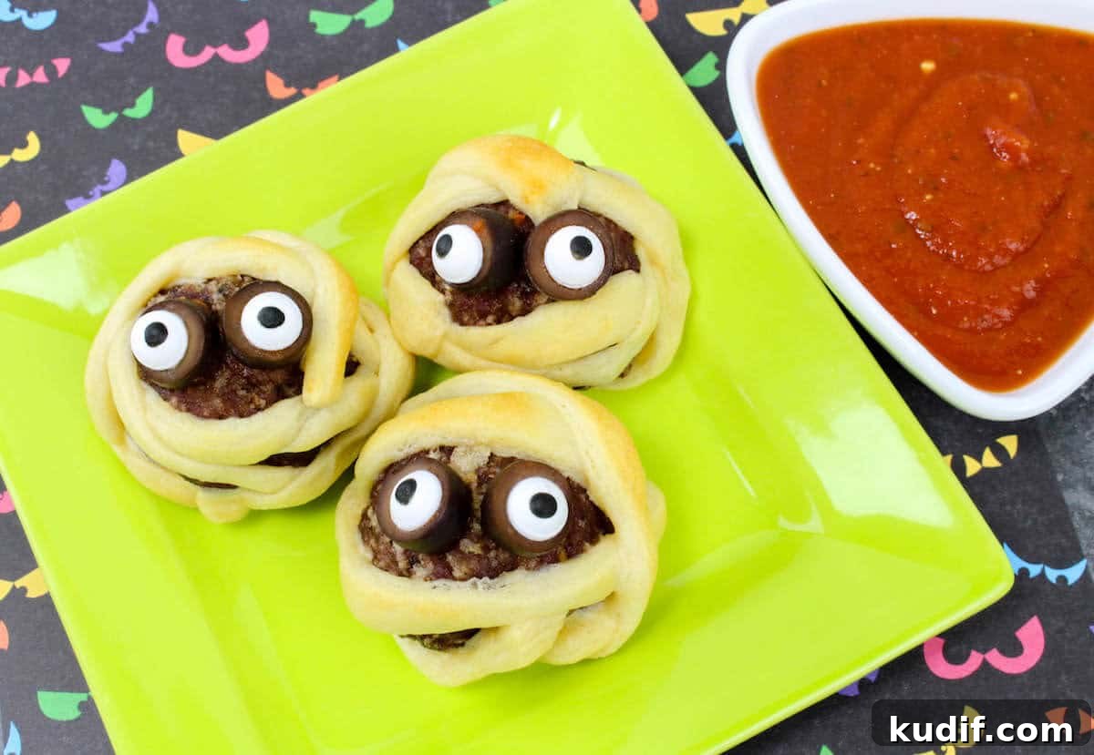 15 Spooky Halloween BBQ Recipes for Party-Worthy Grilling 8 meatballs with a little pastry to look like a mummy head with eyeballs